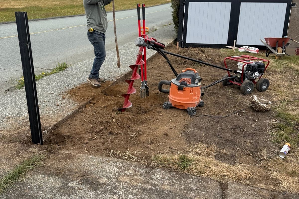 Golden West crew member digging post holes with auger
